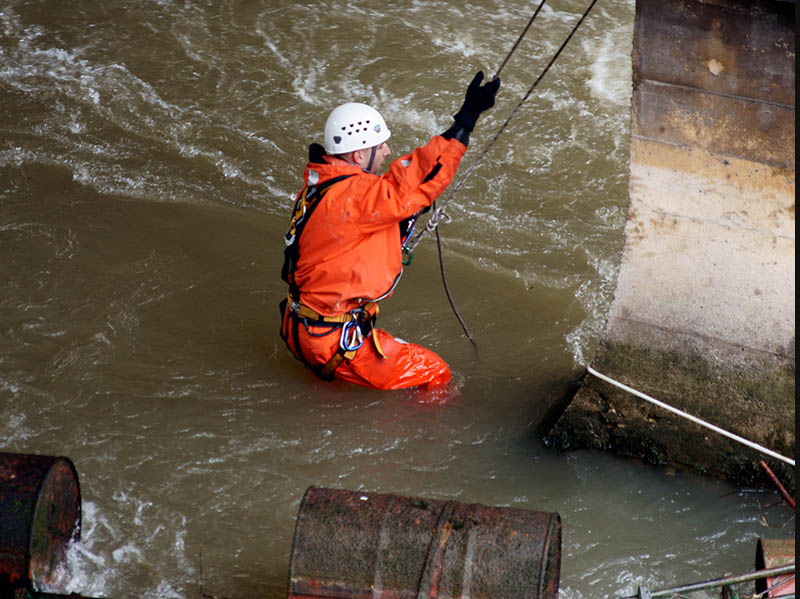 Dramatic image of a safety worker being lowered into rushing waters
