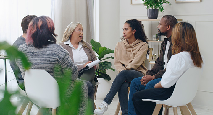 Photo of a group therapy session with participants seated in a circle.