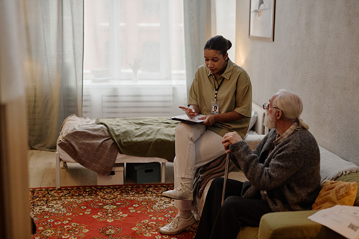 A social worker meets with a client during a home assessment.