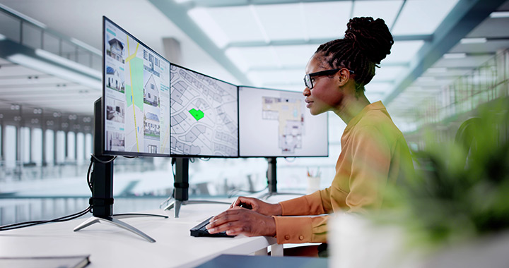 An urban planner looks at a cadastre map on a monitor.