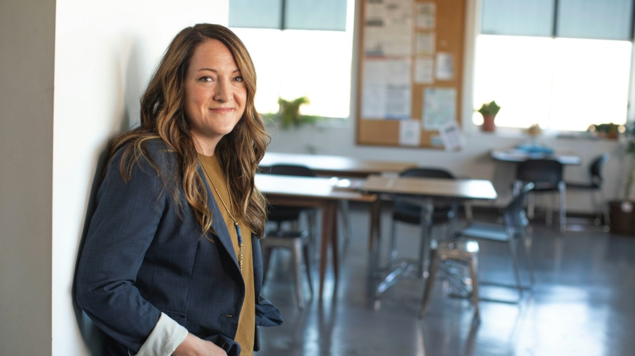 teacher standing at the door to a classroom